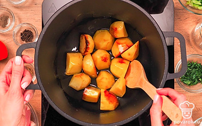 Обжарьте картофель в казане. Поставьте казан на огонь. Налейте растительное масло, закипятите его. Положите картофель и обжарьте со всех сторон, помешивая. Обжаренный картофель достаньте из казана и положите в тарелку.