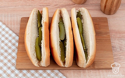 Булочки разрежьте вдоль. Положите в них огурцы, а сверху сосиску.