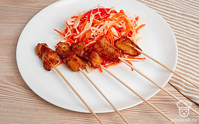 Выложите на тарелку готовый шашлычок из окуня и салат из капусты, моркови и помидора.