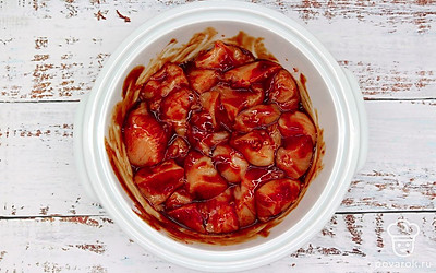 Кусочки курицы выложите в глубокую миску, всыпьте паприку, добавьте зубчики измельченного через пресс чеснока, залейте все соусом терияки и винным уксусом. Все хорошо перемешайте. Миску с содержимым накройте пленкой и поставьте мариноваться мясо птицы в холодильник на ночь.