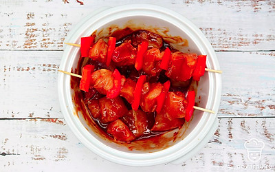 Возьмите деревянные шпажки и соберите шашлычки, нанизывая на них поочередно кусочки курицы и болгарского перца. Собранные шашлычки смажьте остатками маринада с помощью силиконовой кисти.