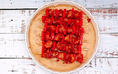 Возьмите противень или форму для запекания, застелите дно пекарской бумагой, выложите на нее шашлычки. Форму с шашлыками поставьте в уже разогретый до 200 градусов духовой шкаф.