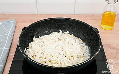 Разогрейте растительное масло в сковороде и выложите в нее лук.