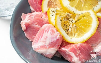 Сделайте маринад для мяса. Кусочки мяса выложите в подходящую емкость, влейте к ним лимонный сок, минеральную газированную воду и масло. Добавьте ломтики лимона, прованские травы и смесь перцев, хорошо перемешайте. Оставьте шашлык мариноваться в темном месте на 6 часов.