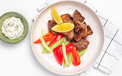 Кусочки жареного мяса выложите на тарелку, украсьте ломтиками сладкого перца и сельдерея. Добавьте к сервировке чесночный соус в пиале.