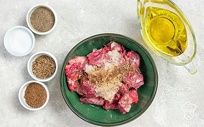 Приготовьте маринад и замаринуйте мясо. В глубокой емкости соедините тертый лук, масло, соль и перец, специи. Полейте лимонным соком. Выложите в маринад говядину. Перемешайте, накройте пищевой пленкой и оставьте на 2-3 часа при комнатной температуре.