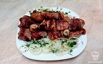 Подавайте шашлык выложив кусочки на кольца маринованного лука, и слегка посыпьте нарезанной зеленью.