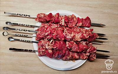 По истечении времени нанизайте свиные порционные куски на шампура и обжарьте на открытом огне до готовности.