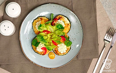 Разложите кабачки по тарелкам, украсьте блюдо зеленью петрушки и половинками помидоров черри.