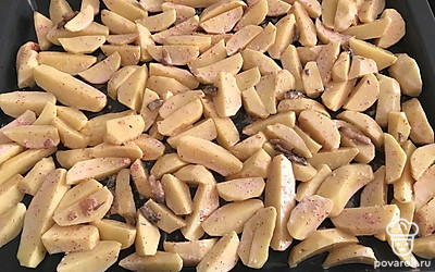 Картофель очистите, нарежьте дольками. Смешайте со специями и майонезом, выложите на противень.