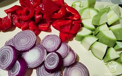 Подготавливаем овощи. Перец и кабачок нарезаем кубиком, лук шинкуем кольцами. Добавляем специи по вкусу.
