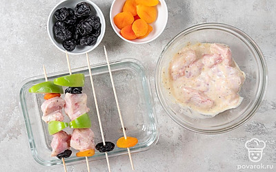 Разогрейте духовку до 190 градусов. Яблоко нарежьте ломтиками. Нанизывайте кусочки мяса на шпажки или шампуры, перемежая их с дольками яблока и сухофруктами. Положите на форму для запекания так, чтобы жир стекал в емкость. Отправьте в духовку на 40 минут. 