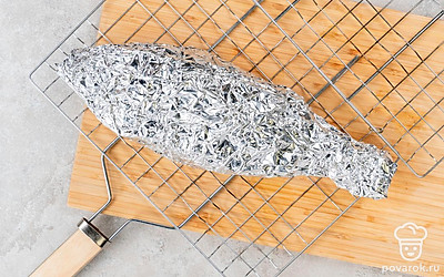 Разожгите костер, дождитесь, когда угли начнут тлеть. Выложите рыбу в фольге на решетку и жарьте около получаса. Чтобы проверить готовность, разверните фольгу и проткните рыбу. Она готова, если мясо легко отходит от костей.