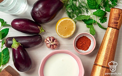 Баклажаны вымойте, обсушите на бумажных полотенцах, отрежьте плодоножку, очистите от кожицы и нарежьте кубиками 1х1см. Зелень вымойте, обсушите на бумажных полотенцах, измельчите. Чеснок очистите от шелухи, измельчите удобным для вас способом. Из половины лимона выжмите сок.