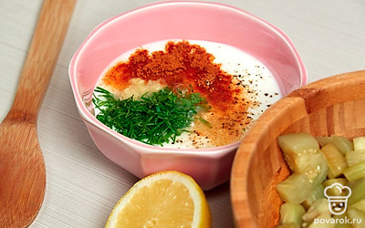 Сделайте заправку. Измельченную зелень выложите в глубокую миску, приправьте черным молотым и красным острым перцем, добавьте измельченный чеснок, лимонный сок, йогурт. Перемешайте.