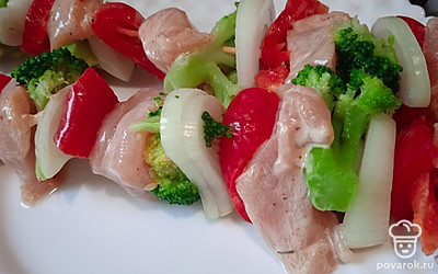 Нанижите на шпажки замаринованное куриное филе, лук, болгарский перец и брокколи. Поставьте в разогретую духовку.