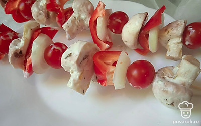 Нанижите на шпажки маринованные шампиньоны, помидоры черри, репчатый лук и болгарский перец.