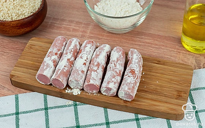 Сосиски разрежьте пополам и обваляйте в муке.