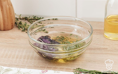 В миске соедините оливковое масло, чеснок, базилик, соль, черный перец, листья тимьяна и розмарина.