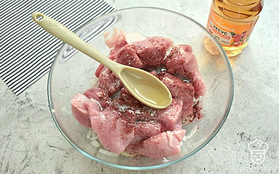 К луку переложите кусочки свинины. Добавьте соль, приправу для шашлыка. Влейте растительное масло и яблочный уксус.