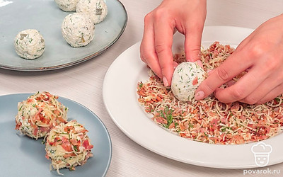 Обваляйте сыр. Шарики из сыра, зелени и огурцов обваляйте со всех сторон в смеси из бекона, чеддера и укропа. Готовую закуску уберите в холодильник на 30 минут.