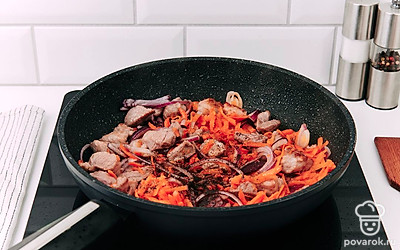 Добавьте лук и морковь. Перемешайте, посолите и поперчите по вкусу. Обжаривайте овощи и мясо вместе.