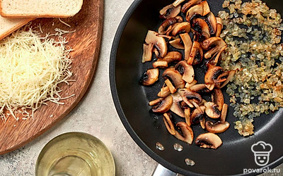 Приготовьте грибы. Разогрейте сковороду и обжарьте лук. Когда он приобретет легкий золотистый оттенок, добавьте шампиньоны. Помешивая, жарьте их в течение 7-10 минут. Посолите и поперчите по вкусу.