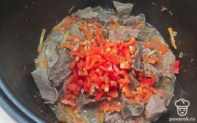 Измельчите луковицу и обжарьте лук вместе с мясом до золотистого цвета в чаше мультиварки в режиме «жарка» в течение 10 минут. Морковь нарежьте крупными кусочками и добавьте к мясу. Затем добавьте измельченный болгарский перец. Жарьте мясо вместе с овощами еще 5 минут. Добавьте чеснок, пропущенный через пресс и жарьте еще около 1 минуты.