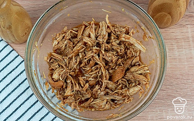 Не вынимая курицу из соуса, разделите ее на волокна.
