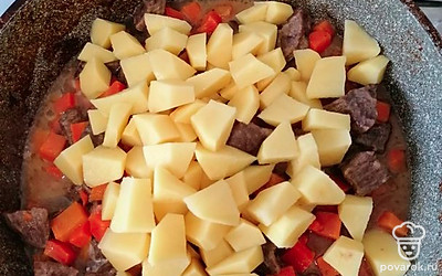 Помыть, почистить и нарезать крупными кусочками картошку. Добавить в сковороду.