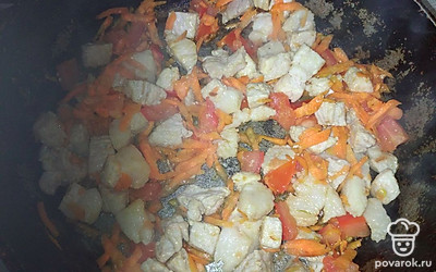 Добавляем растительное масло. Поджариваем мясо на большом огне, затем добавляем морковь и помидор, снова поджариваем вместе с овощами.