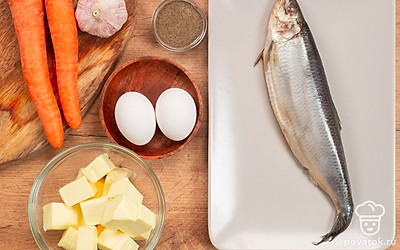 Сварите яйца и морковь, остудите их и очистите. Очистите зубчик чеснока. Почистите сельдь и удалите кости. Вымойте и разделите на мелкие веточки петрушку. Батон нарежьте тонкими ломтиками и приготовьте из него тосты.