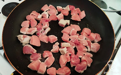 Мясо нарежьте кубиками, выложите на разогретую сковороду. Мясо даст сок. Накройте его крышкой и тушите пока жидкость не выпарится. В это время порежьте овощи.