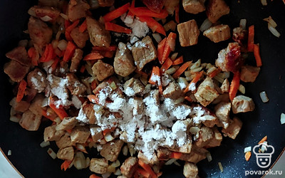 Насыпьте на мясо столовую ложку муки, перемешайте, обжарьте немного. Добавьте томатную пасту и ещё немного обжарьте.