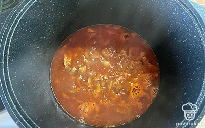 Доливаем в казан томатную пасту и кипяток. После закипания постепенно вводим муку, хорошо перемешивая. Солим по вкусу, закрываем казан крышкой и тушим блюдо 20 минут на медленном огне. Готово!