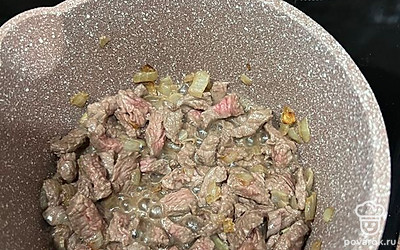 Мелко режем филе говядины и добавляем к луку. Обжариваем на среднем огне до корочки. Солим и перчим по вкусу.