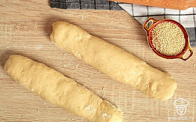 Сформируйте багеты. Разделите тесто на две равные части. Каждую из них раскатайте в пласт толщиной не более 1 см и площадью примерно 20x40 см. Затем сверните пласт в рулет, но не слишком плотно, чтобы при выпекании он не лопнул по краям. То же самое повторите со второй частью.