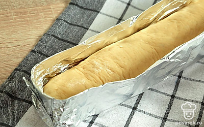 Подготовьте форму для багетов. Возьмите фольгу, отмерьте нужную длину с запасом на бортики, сложите фольгу в 3-4 слоя, после чего отрежьте. Затем посередине сделайте сгиб-бортик и загните длинные края по бокам. По длине и ширине форма должна превышать размер багетов. Форму смажьте растительным маслом, присыпьте мукой.