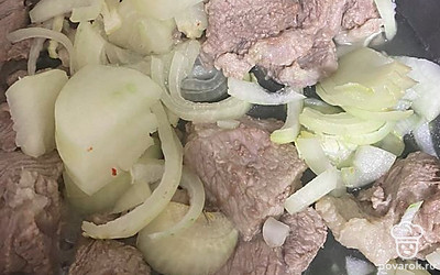 Луковицу нарежьте полукольцами и добавьте к мясу.