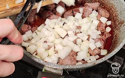 Как только мясо схватится (появится золотистая корочка), выложите лук. Обжаривайте 2-3 минуты (огонь при этом можно убавить до минимального значения).