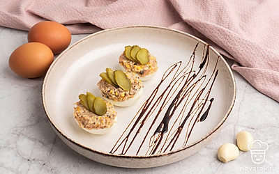 Фаршированные яйца шпротами, сыром, огурчиками выложите на тарелку и украсьте на свой вкус. Приятного аппетита!