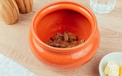 На дно горшочка выложите жареный лук.