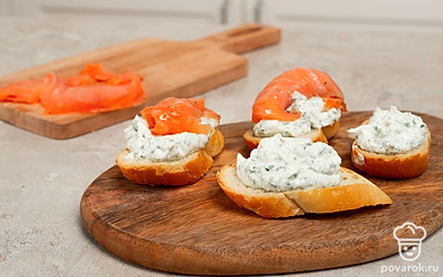 Приготовьте тосты с лососем. Каждый тост щедро намажьте творожной массой, сверху красиво положите ломтики слабосоленого лосося.