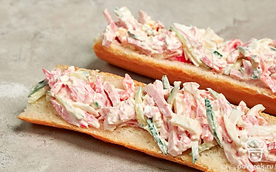 Приготовьте блюдо. Разрежьте багет вдоль на две части. В каждой из них сделайте небольшие углубления. Готовую начинку распределите по двум частям багета, укладывая ее в углубления.