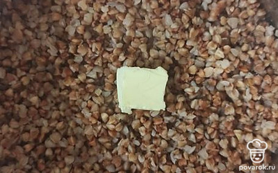 В горячую гречневую кашу добавить сливочное масло, хорошо перемешать.