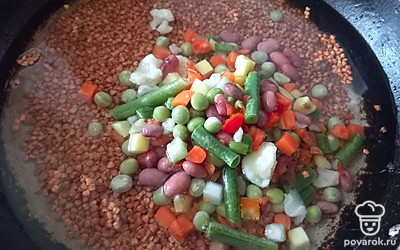 Добавьте туда же заранее размороженную овощную смесь. Посолите и хорошенько перемешайте.