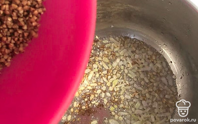 В кастрюлю к обжаренному луку добавить промытую крупу.