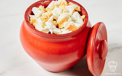 Вареные яйца нарежьте кубиками и добавьте в горшочек с готовой кашей. Хорошо перемешайте.