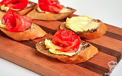 Приготовьте тосты. Смажьте тосты сливочным маслом. Сверните кусочек лосося в трубочку и красте им тост. Расправьте верхнюю часть, чтобы лосось по форме напоминал розочку.