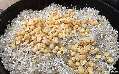 Выложите замороженную кукурузу. Можно использовать кукурузу консервированную, только добавлять ее надо после того, как рис будет готов.